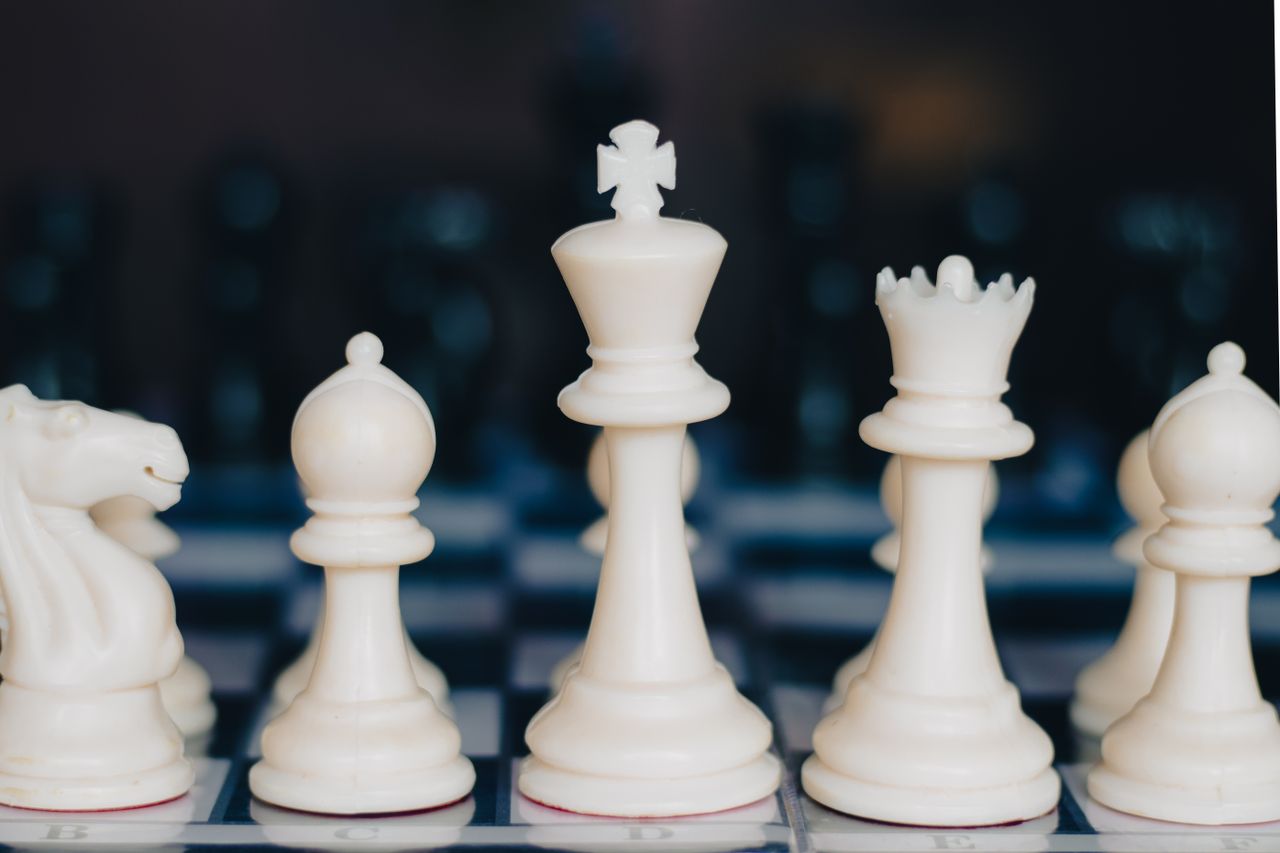 Close-up photo of aligned and focused chess pieces, showcasing strategic planning.
